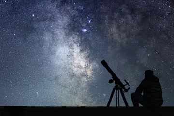 Foto op Canvas Man with astronomy  telescope looking at the stars. © allexxandarx