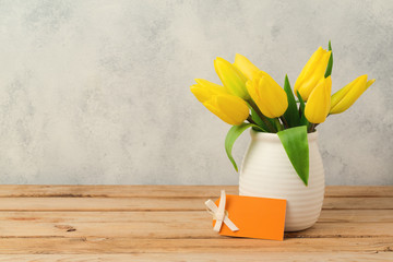 Tulip flower bouquet on wooden table over rustic background