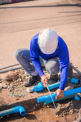 Construction worker,Repairing a broken water pipe on the concrete road.