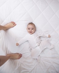 Happy addorable baby boy and the legs of his mother.