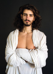 Fototapeta na wymiar guy with long curly hair in a white drapery photo