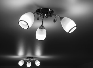 Two chandeliers with three lamps light the room