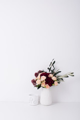 roses and carnations in a vase in white interior