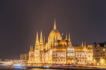 Obraz premium Night view of the Hungarian Parliament Building on the bank of the Danube in Budapest