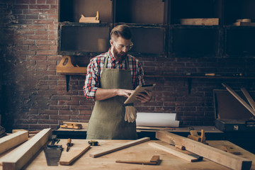 handsome cabinetmaker look at digital tablet  Stylish craftsman with brutal hairstyle and saved...