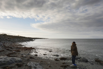 West coast of Ireland, woman looking at The Atlantic ocean.