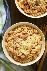 Nudeln mit Thunfisch- und Tomatensauce, bestreut mit geriebenem Käse, fotografiert mit natürlichem Licht (Selektiver Fokus, Fokus auf das Gericht)