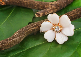 Jewellry ring as flower on green leafs background, copyspace