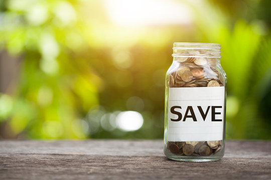 SAVE word with coin in glass jar with. Savings and financial investment concept.