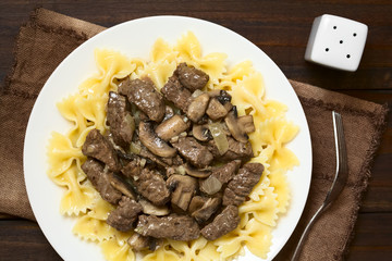 Rindfleisch mit Pilz in Cremesauce auf Farfalle Pasta, auch Boeuf Stroganoff genannt, fotografiert...