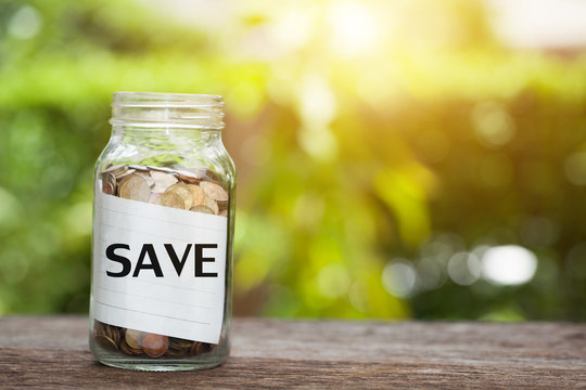 SAVE word with coin in glass jar with. Savings and financial investment concept.