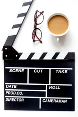 Screenwriter desktop with movie clapper board white background top view