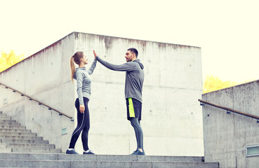 happy couple giving high five outdoors