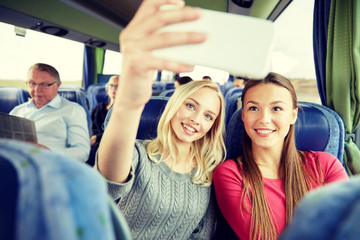 women taking selfie by smartphone in travel bus