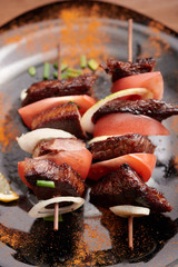 shish kebab on a plate on a wooden table