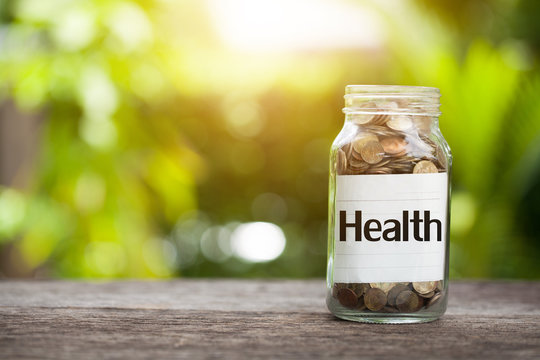 Health word with coin in glass jar,  concept siphons money and Health insurance.