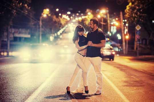 young couple dancing on the road