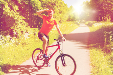 happy young man riding bicycle outdoors