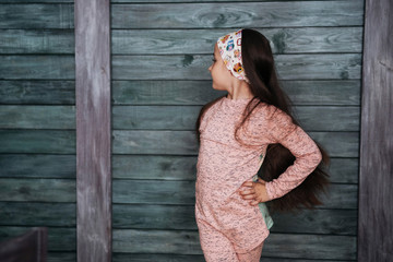 Stylish teenage girl leaning against a wall