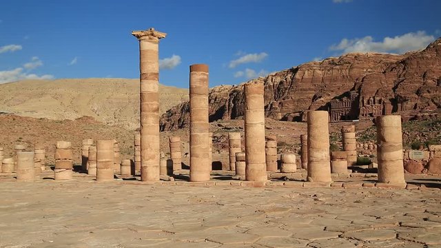 Ancient columns of Great Temple or Temple of Winged Lions in Petra - historical and archaeological rock-cut city in Hashemite Kingdom of Jordan. Royal Tombs carved in the mountain on the background