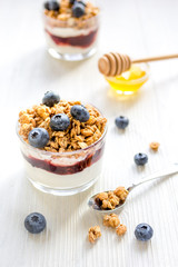 Fitness breakfast with muesli, honey and milk on white table