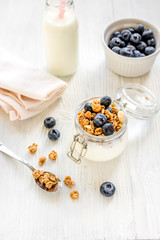 Obraz na płótnie Canvas Homemade granola with blueberries in jar on white kitchen background
