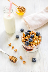 Fitness breakfast with granola, milk and honey on white background