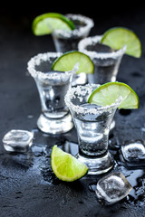 Alcohol party with tequila, ice and salt on black background