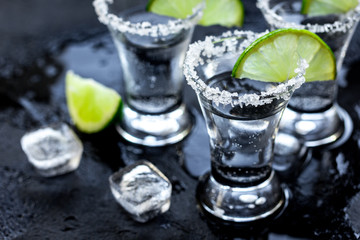 Alcohol party with tequila, ice and salt on black background