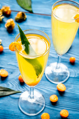 cocktail with physalis in glass on wooden background