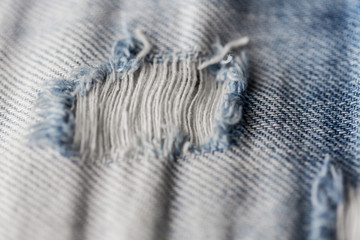 close up of hole on shabby denim or jeans clothes