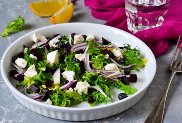 Fresh salad frieze with feta and beetroot on a concrete background