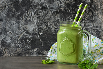 Detox drink - Green smoothie with spinach, apple and yogurt on a concrete background. Organic food.