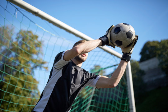 goalkeeper with ball at football goal on field
