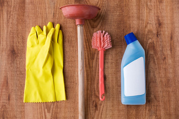plunger with cleaning stuff on wooden background