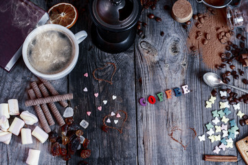 Fototapeta na wymiar Abstract background with sweets and a cup of black coffee on a gray wooden surface