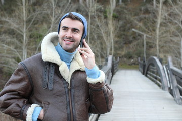 Man calling by phone from the forest in the winter with copy space 