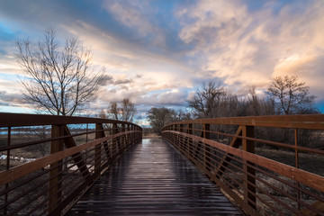 Fototapeta na wymiar Rain-Slick Footbridge At Sunset