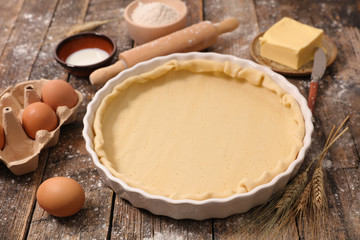 raw dough with rolling pin and flour