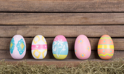 Row of Colorful Easter Eggs Against a Rustic Wooden Background