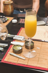 Mimosa next to joint, grinder, lighter, and other cannabis accessories