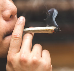 Man smoking joint, cigarette, or spliff.