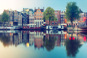 Fototapeta na wymiar Amsterdam canal Amstel with typical dutch houses and boats during sunrise, Holland, Netherlands.