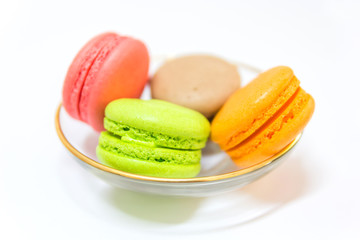 Sweet and colourful french macaroons or macaron in a glass bowl on white background, Top view with copy space for your text.