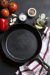 Cast Iron Skillet with copy area on black background with ingredients