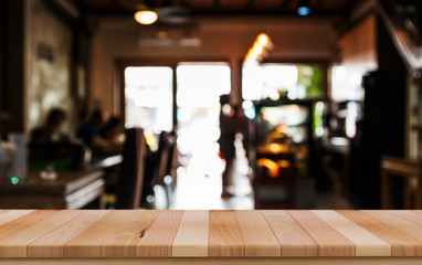 Empty wood table top with blur of people in coffee shop