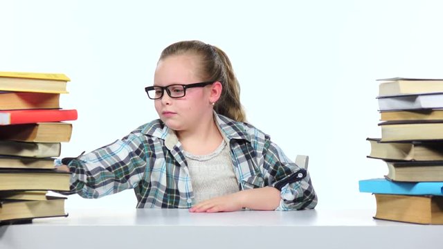 Little girl choose an interesting book for a long time she finds it. White background