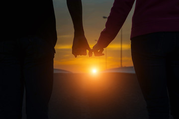 Happy couple holding hands in the sunset