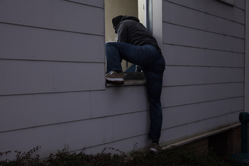 Burglar Entering House Through Window