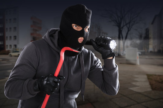 Burglar With A Crowbar And A Flashlight